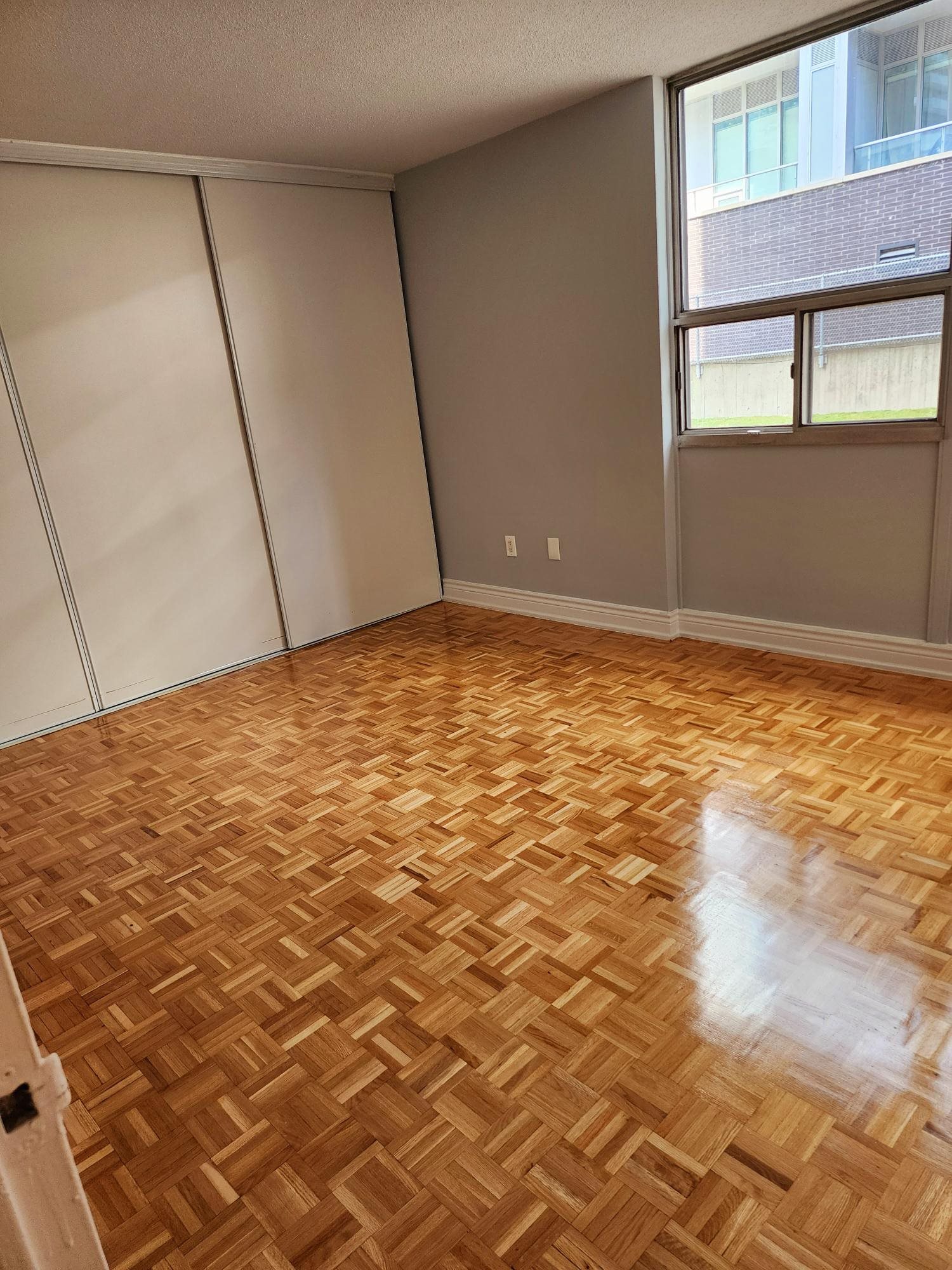 A room with wooden flooring and a window.